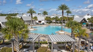 A resort with a central swimming pool, lounge areas, and multiple bungalow-style accommodations. - Prominence Townhome with LSV and Bikes (Watersound)
