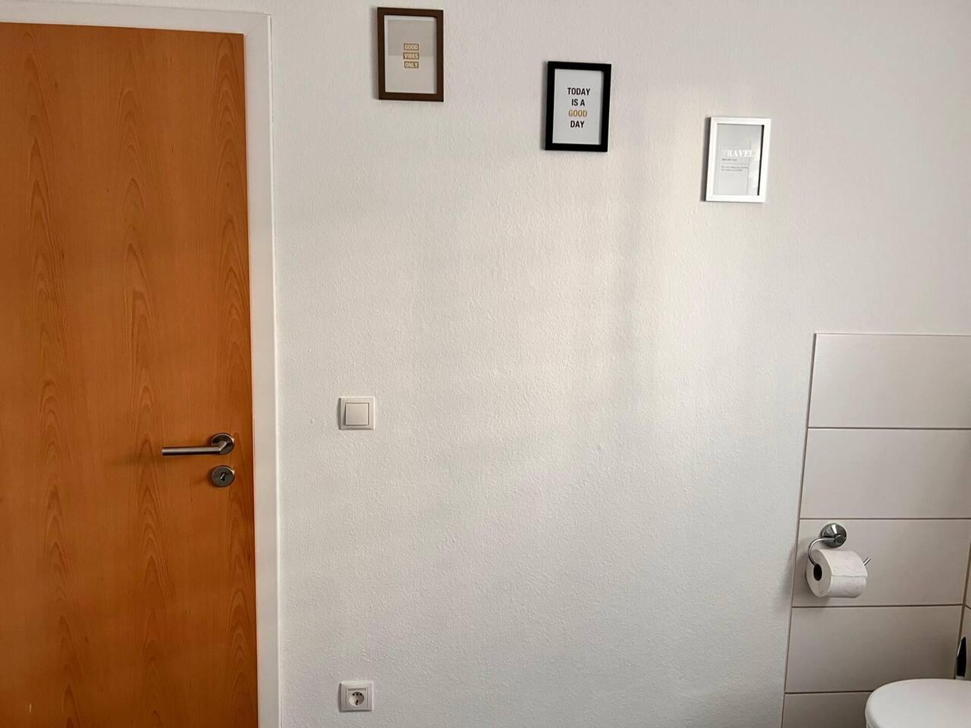 Ein Badezimmer mit Toilette, Toilettenpapierhalter und Tür.
