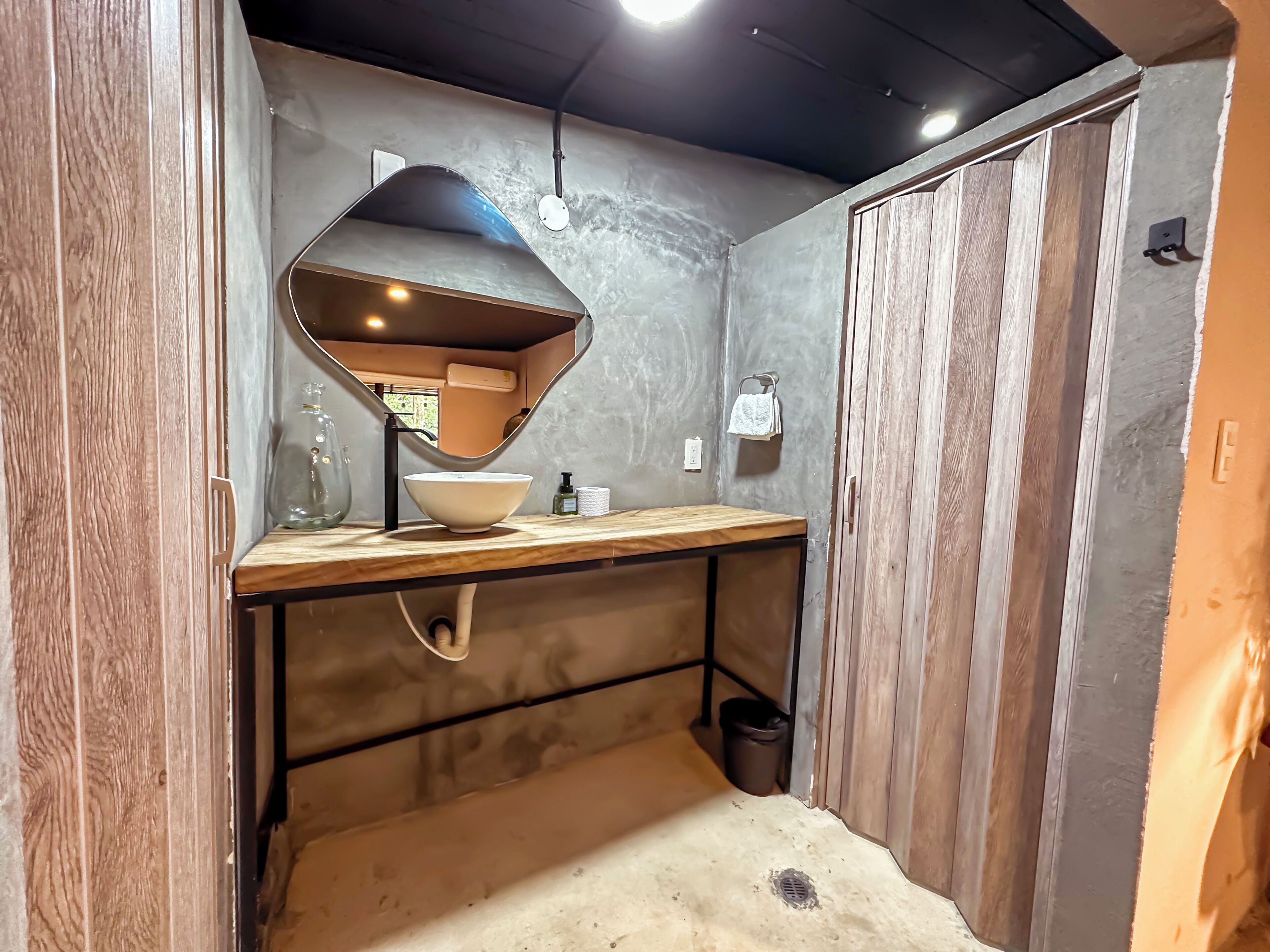 A bathroom with a wooden vanity, a large mirror, and a sink.