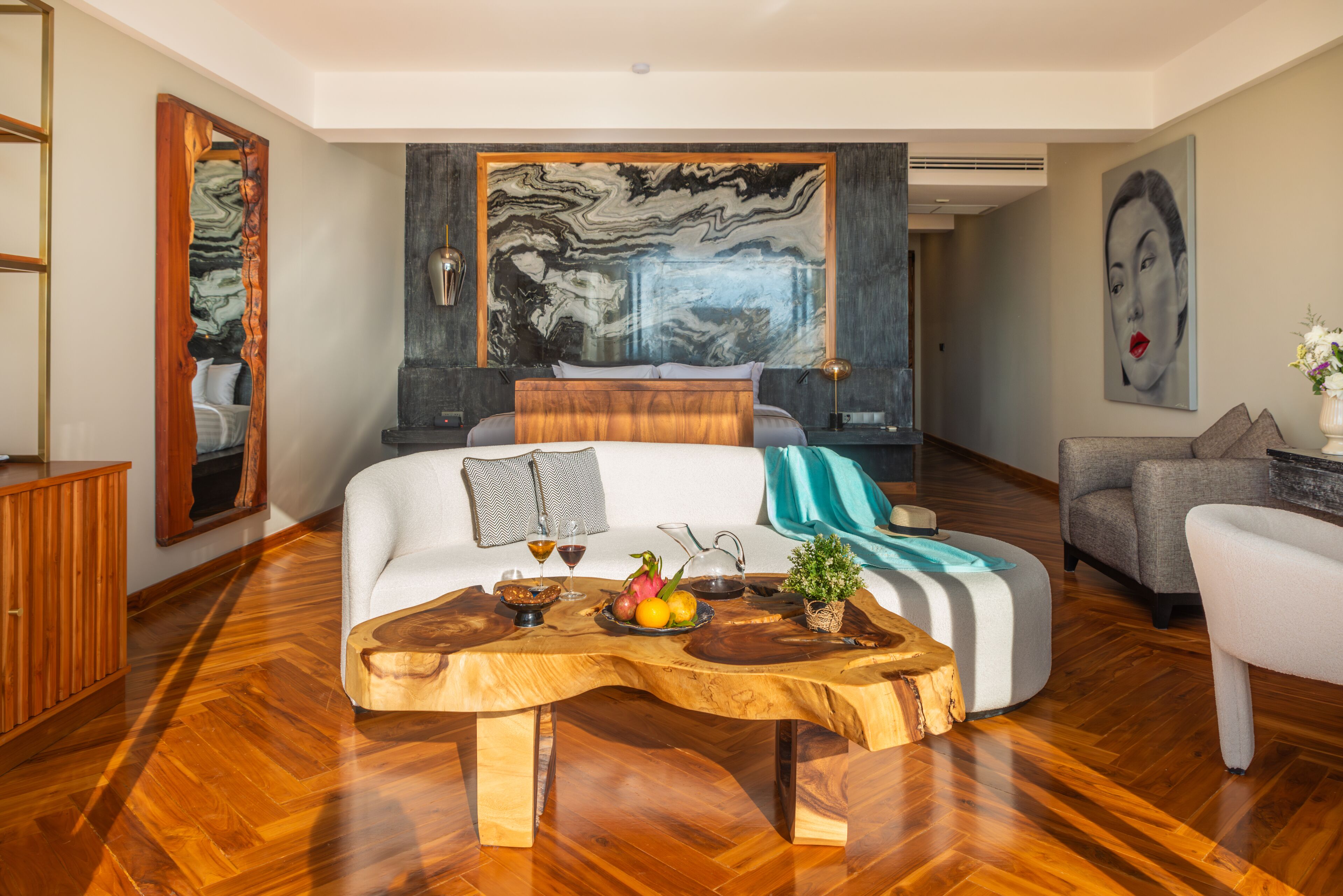 A modern living room with a wooden coffee table, a sofa, and a large abstract painting on the wall.