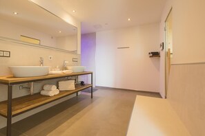 A modern bathroom with two sinks, a vanity with shelves, and a large mirror. - Stoahaus - 140 sqm earth house with private spa (Breitenberg)