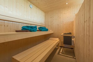 A wooden sauna with benches and shelves for towels. - Stoahaus - 140 sqm earth house with private spa (Breitenberg)