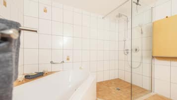 Ein Badezimmer mit Badewanne, Duschkabine und Toilette.