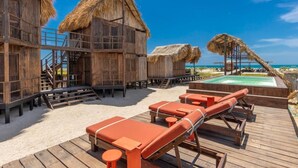 A wooden beachside structure with thatched roofs, a pool, and lounge chairs. - Casa Solea (Manaure)