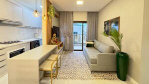 Uma cozinha moderna com ilha central, armários embutidos e uma área de refeições com sofá e cadeiras.