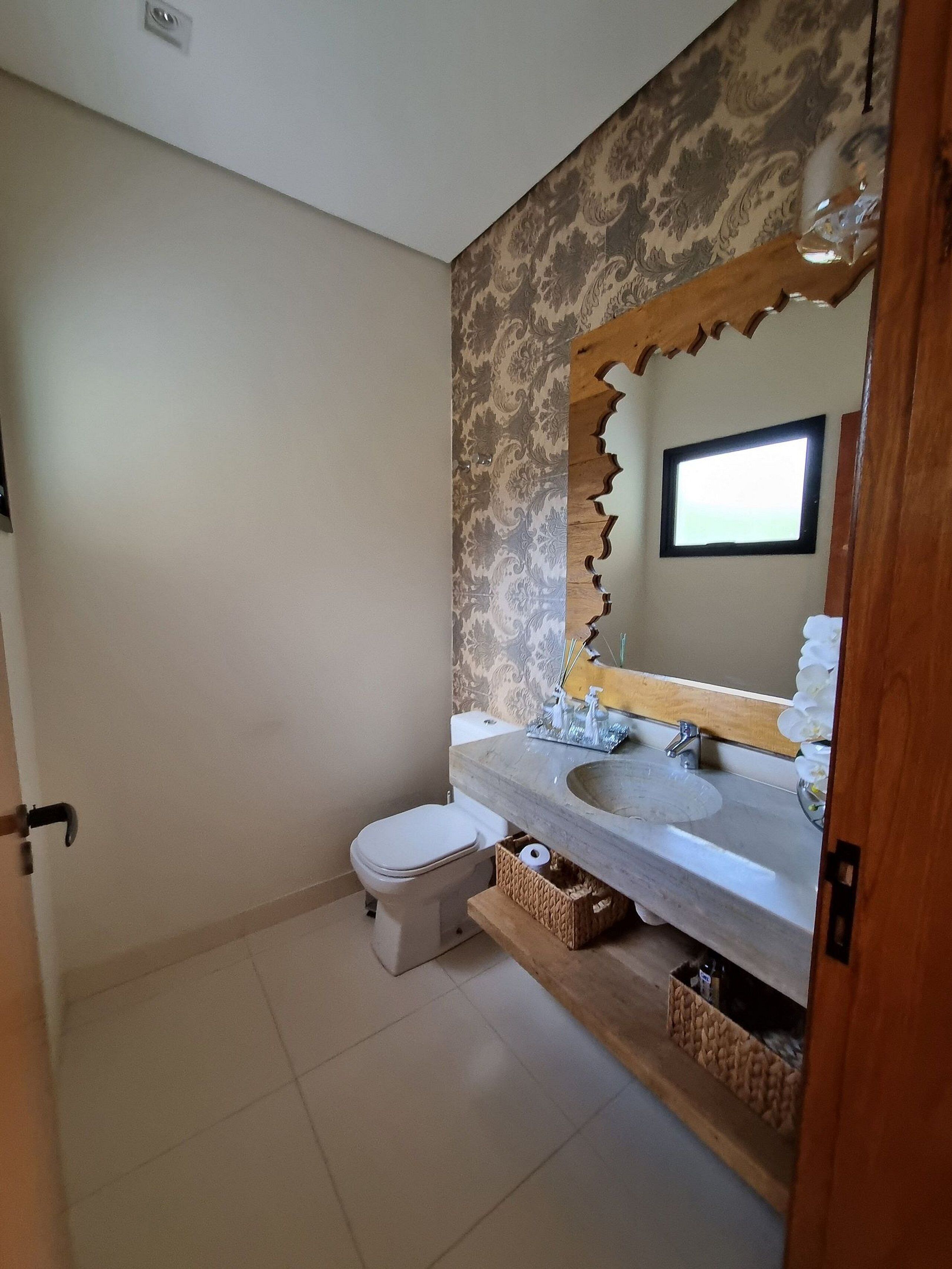 A bathroom with a toilet, a sink, and a mirror.