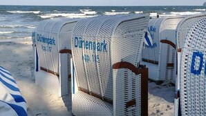 Strandstoelen met de aanduiding 'Durenpark' en uitzicht op de oceaan.