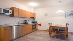 Een koffiezetapparaat/waterkoker, een koelkast, een oven, een kookplaat