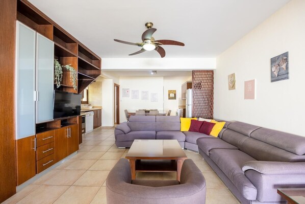 Ein modernes Wohnzimmer mit einem Ecksofa, einem Couchtisch und Holzausbau.