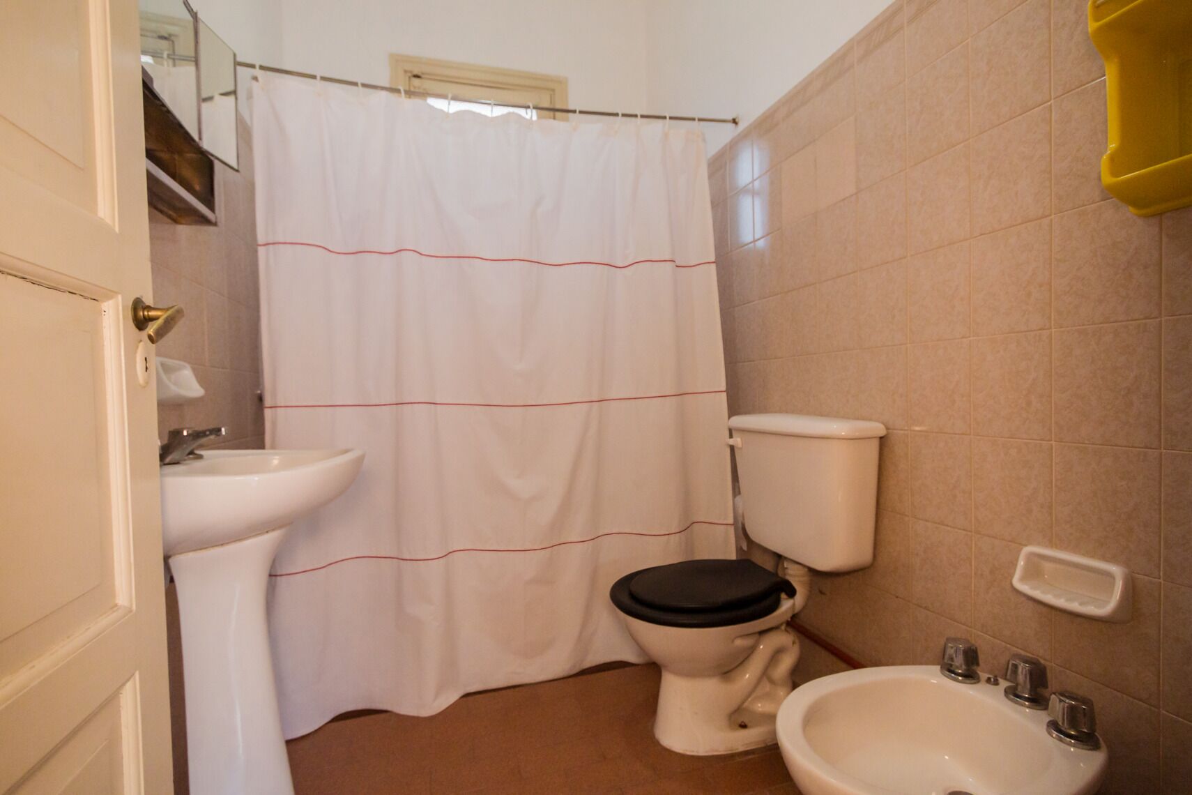 Une salle de bain équipée de toilettes, d’un bidet et d’un lavabo.