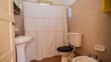 Un baño con inodoro, bidé y lavamanos.