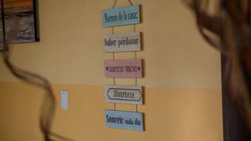 A wall with wooden signs in a foreign language, possibly a hotel or guest room.
