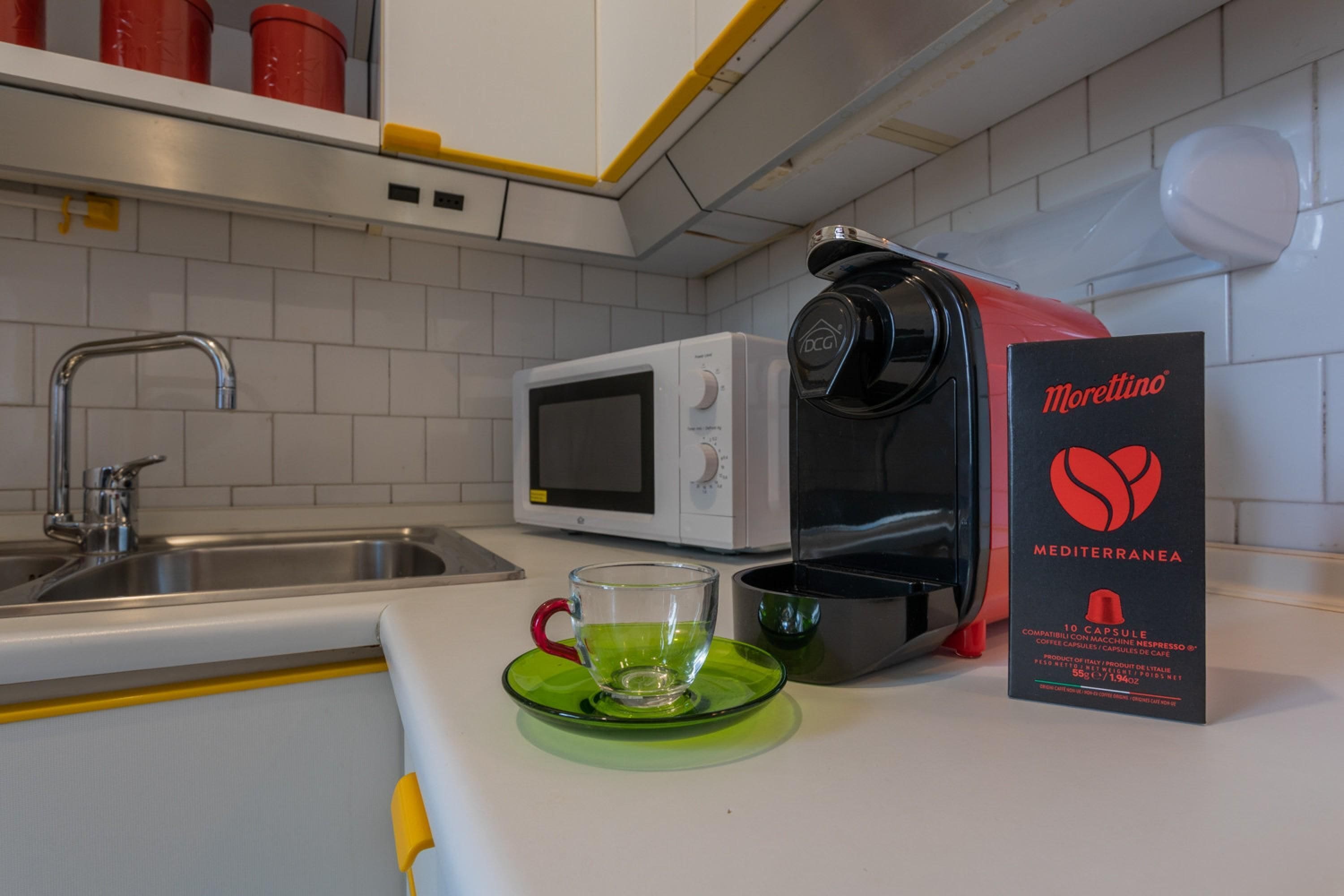 Une cuisine équipée d’un four à micro-ondes, d’une machine à café et d’une machine à expresso Morettina.