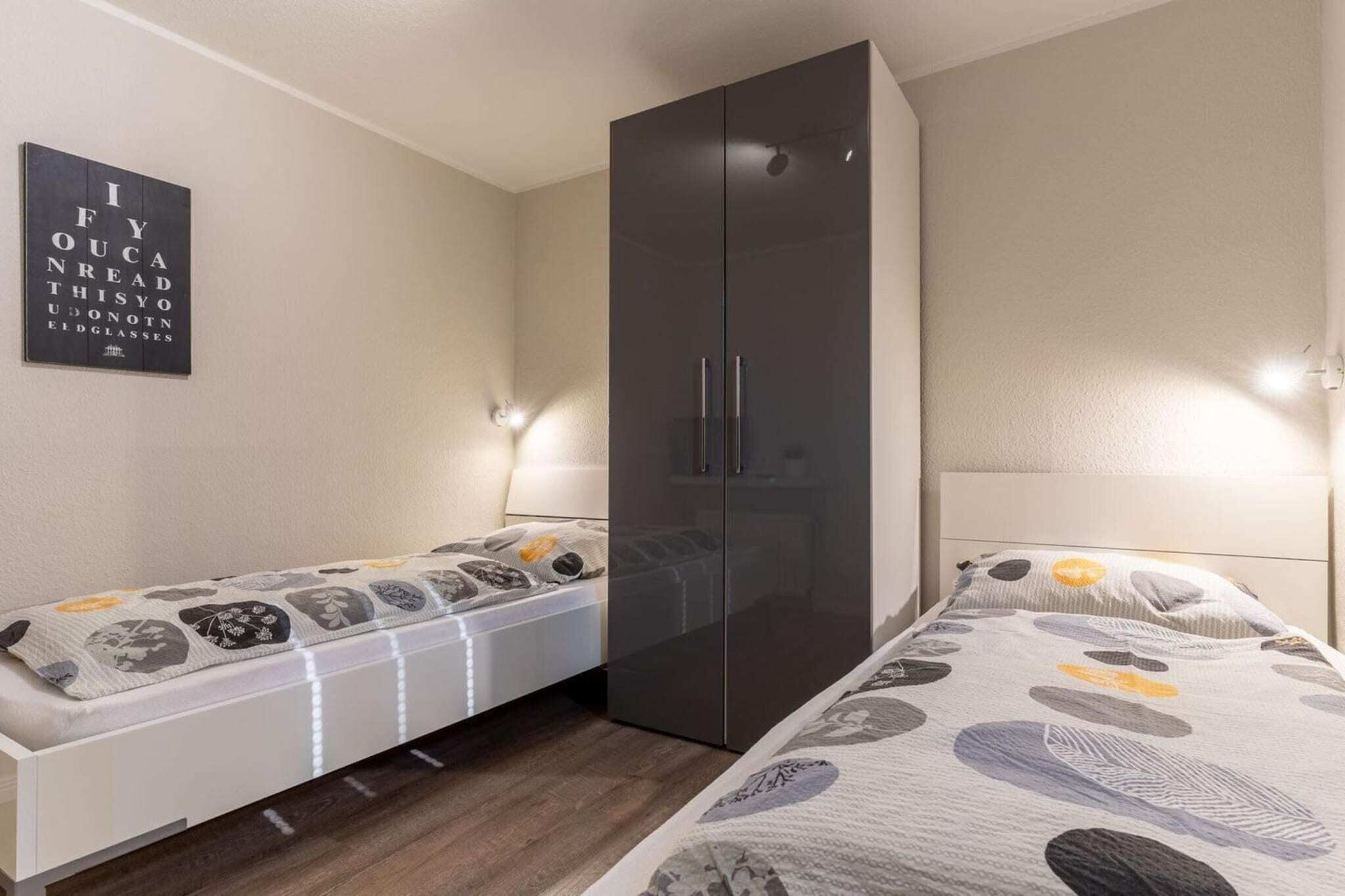 Ein Schlafzimmer mit Bett, Kleiderschrank und einer Wandlampe.