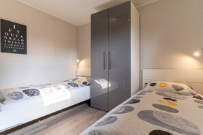 Una camera da letto con un letto, un armadio e una lampada a parete.