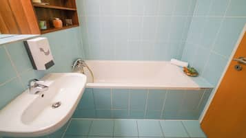 Flora Cozy Apartment by CHORS | Bathroom | Bathtub, towels, soap, shampoo