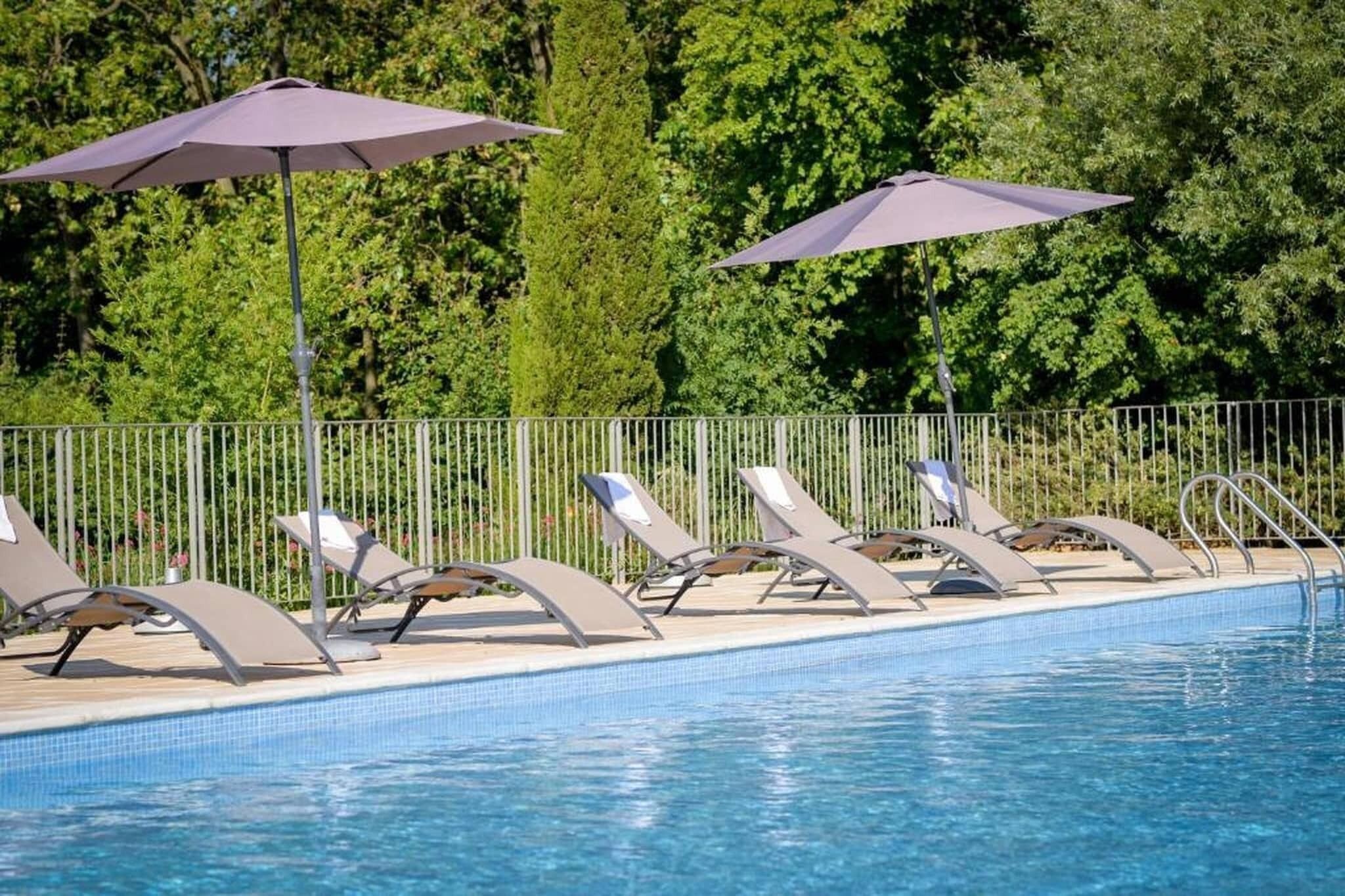 A poolside area with lounge chairs and umbrellas.