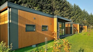 A row of modern, wooden cabins with large windows and a grassy lawn. - Chalet near Beach & Nature in Austria (Kramsach)