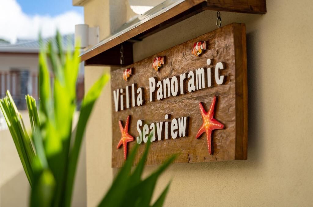 A wooden sign with the text "Villa Panoramic Seaview" and two red starfish decorations.