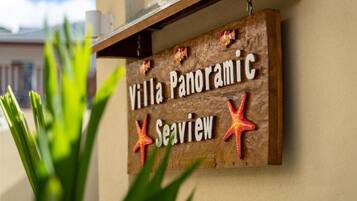 A wooden sign with the text "Villa Panoramic Seaview" and two red starfish decorations.