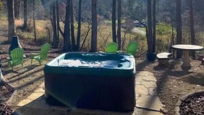 A hot tub in a forested area with chairs and a table. - Mountain Hideaway - HOT TUB (Horse Shoe)