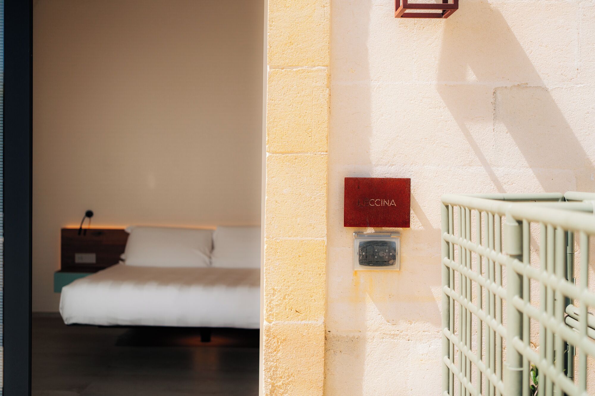 Ein Zimmer mit einem Bett, einem kleinen Tisch und einem an der Wand befestigten Schild mit der Aufschrift 'LECCINA'.