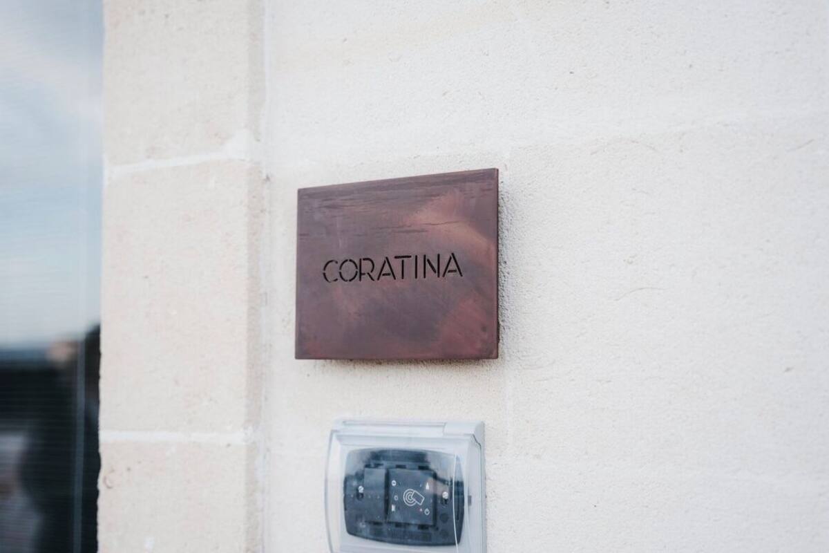 Ein an der Wand befestigtes Schild mit der Aufschrift 'CORATINA' und einer darunterliegenden Bedienkonsole.