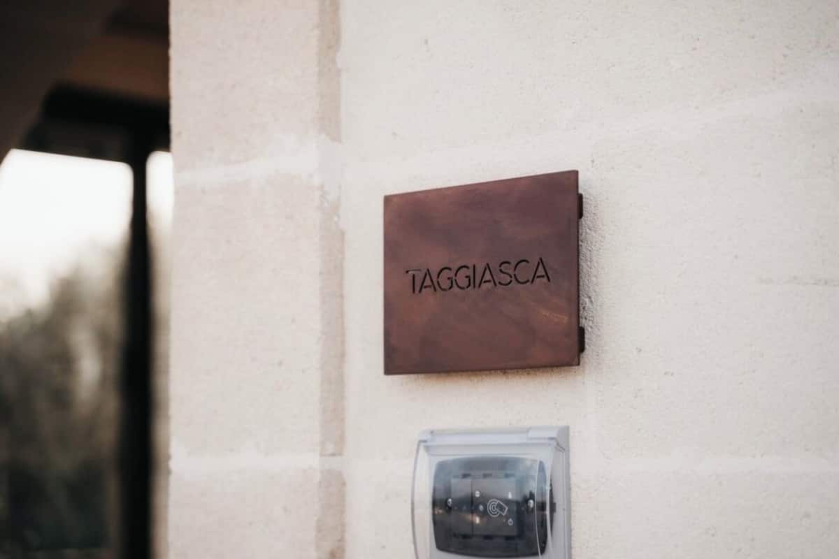 Ein an der Wand befestigtes Schild mit der Aufschrift 'TAGGIASCA' und einer Verteilerbox darunter.