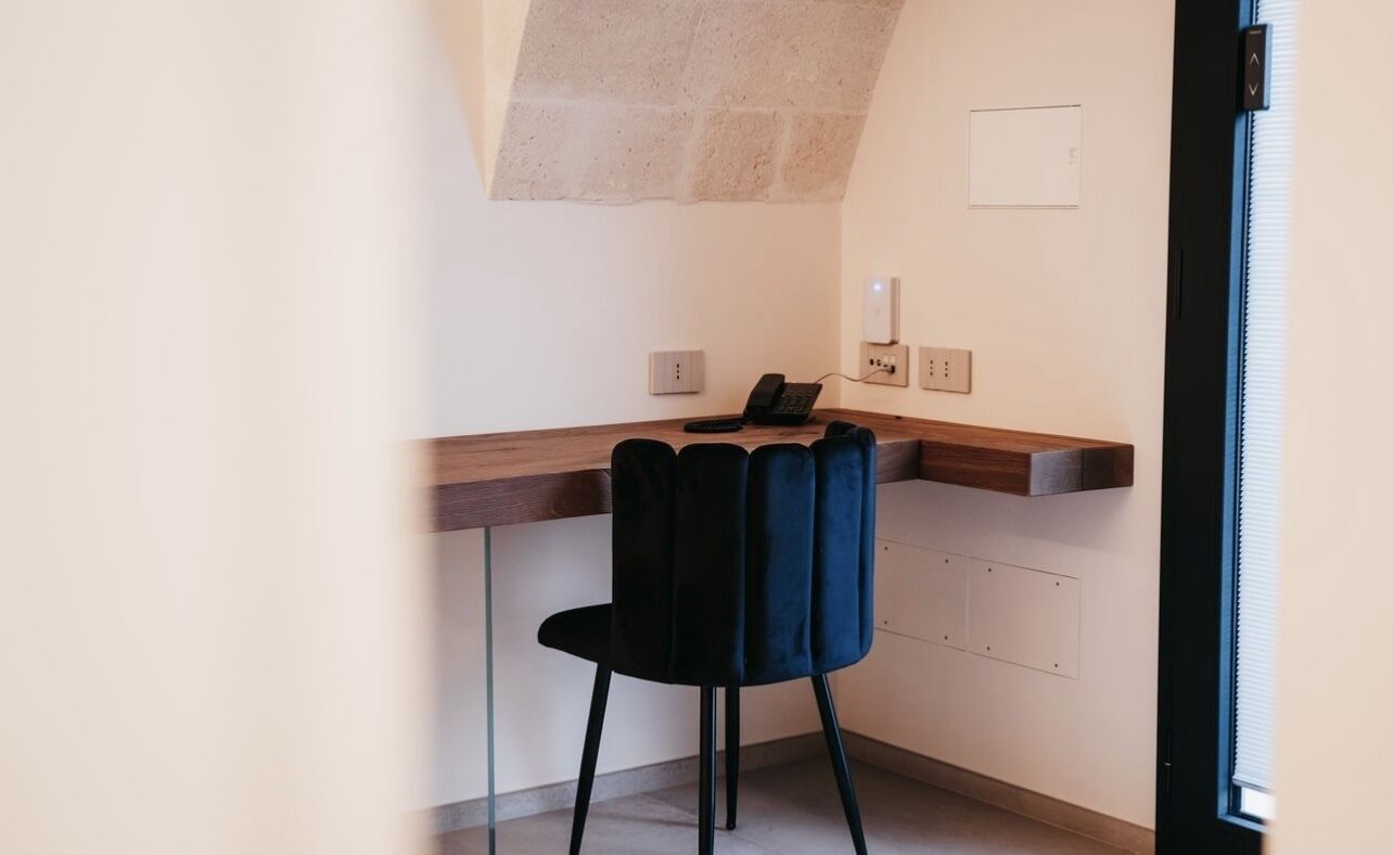 A small office space with a desk, a chair, and a telephone.