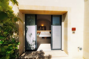 L’entrée d’un hôtel avec un lit, une petite table et un écran de télévision.
