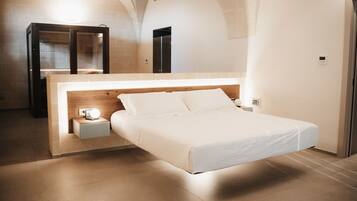 Un dormitorio moderno con diseño minimalista, que presenta una cama con cabecera de madera, una mesita de noche con lámpara y un espejo grande.