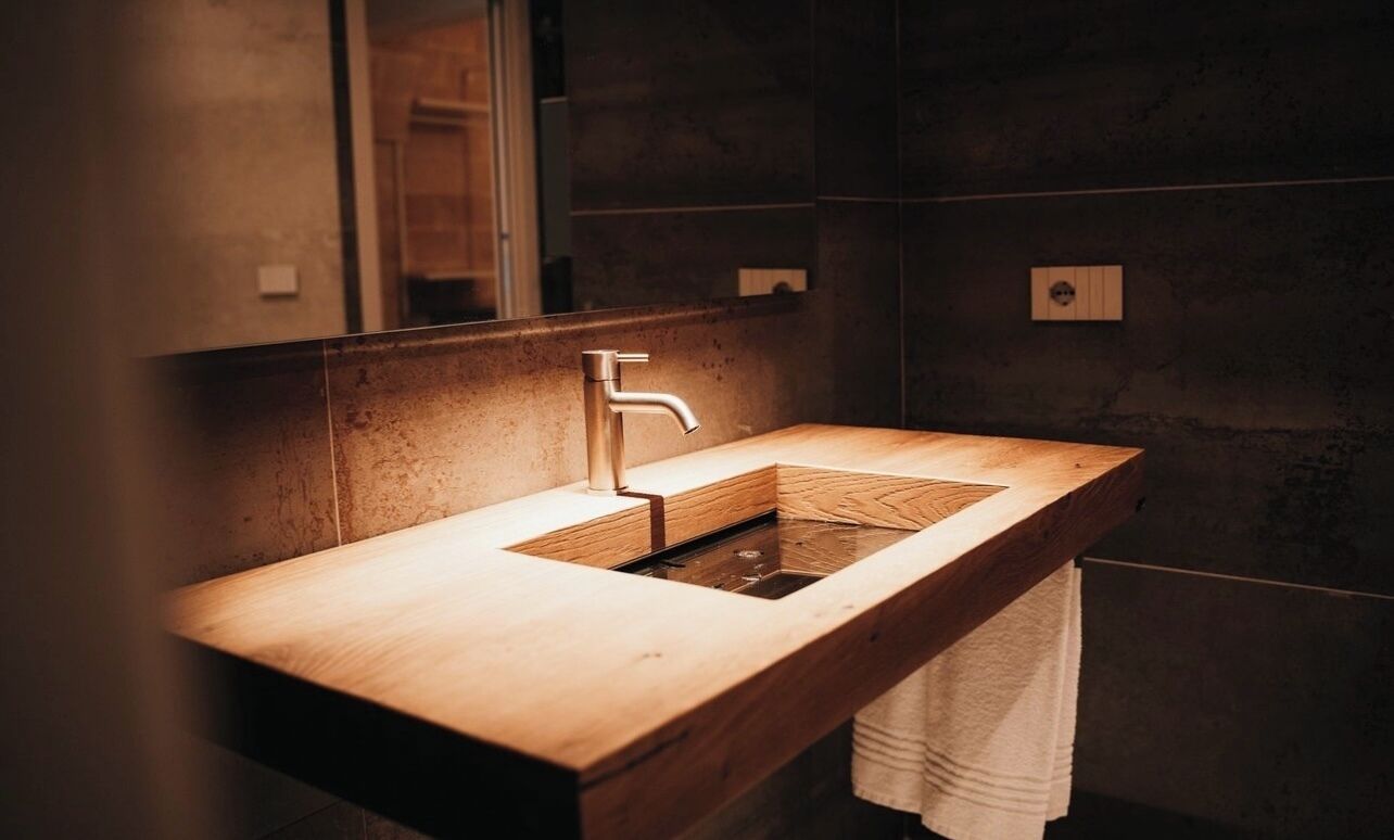 Une salle de bain moderne avec un meuble-lavabo en bois, un seul vasque et un miroir.