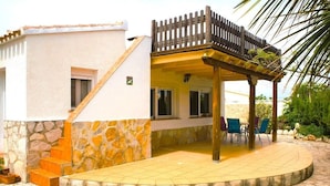 A house with a stone exterior, a wooden staircase, a covered patio with chairs, and a wooden fence. - SAONA VILLAS (AS CHARL): villa for 8 people, private swimming pool, air co (Dénia)