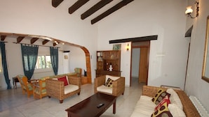 A spacious living room with wicker furniture, a coffee table, and a sofa with patterned cushions. - SAONA VILLAS (AS CHARL): villa for 8 people, private swimming pool, air co (Dénia)