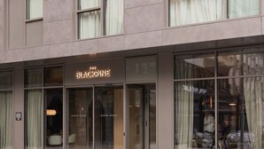 Een hotelentree met glazen deuren, een bord met de tekst 'The Blackpine', en een bord dat 'Small Luxury Hotels' aangeeft.