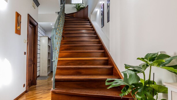 A wooden staircase with a handrail, leading to an upper floor. - I Barcaioli (Giardini Naxos)