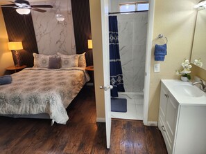 A hotel room with a bed, a bathroom with a bathtub, and a sink. - Family Largue House: Slide, Game Room & Jacuzzi
 (Las Vegas)