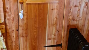 A wooden door with a frosted glass window, a white doorbell, and a black metal handle.