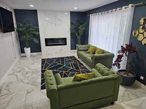 A living room with a sofa set, a patterned rug, a fireplace, and potted plants. - 2-Connected Villas Luxury Vacation Villa 5,250sqft with FREE Heated pool
(Las Vegas)