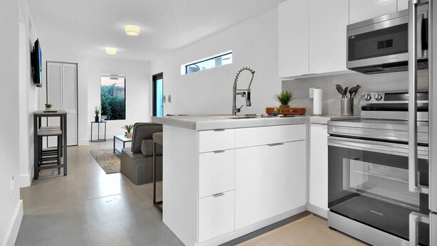 A modern kitchen with white cabinetry, stainless steel appliances, and a built-in oven. - Nice Villa in Miami 4 (Miami)