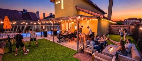 A backyard with a pool, outdoor seating, and a barbecue area.