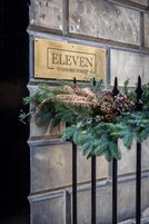 A brass plaque with 'ELEVEN STAFFORD STREET' on a stone wall.