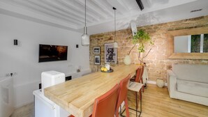 A modern kitchen with a wooden table, red chairs, a stone wall, and a white sofa. - Hot Hot Hot Loft Faubourg Saint-Denis (Paris)