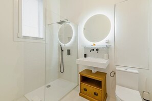 A modern bathroom with a glass shower enclosure, a toilet, and a sink with a mirror above it. - |Aaa|- Pure & Natural Massilia City Center (Marseille)