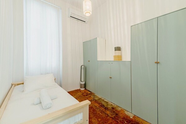 Une chambre à coucher avec un lit, une armoire et un miroir.