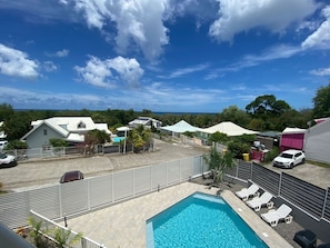 Uma área residencial com piscina, quintal cercado e casas.