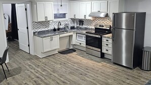 A modern kitchen with white cabinets, a stainless steel refrigerator, a built-in oven, and a microwave. - Boxcar Bunker - Downtown living at its finest
 (Holly)