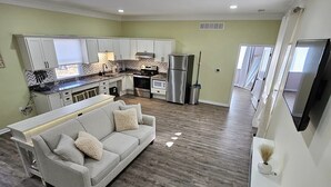 A modern apartment with a living room, kitchen, and dining area.