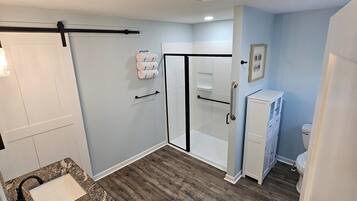 Un baño con ducha, inodoro y lavamanos.