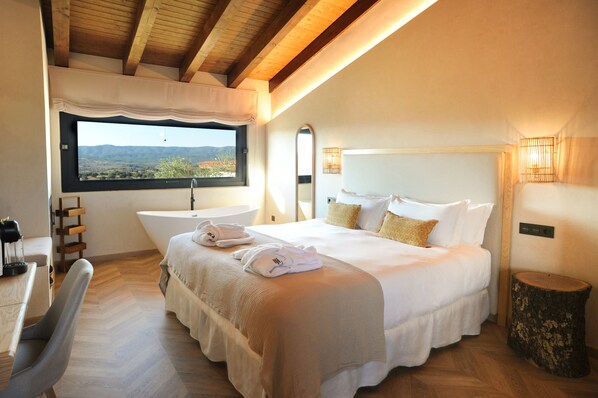Un dormitorio con una cama grande, una ventana con vistas, un lavabo y un techo de madera.